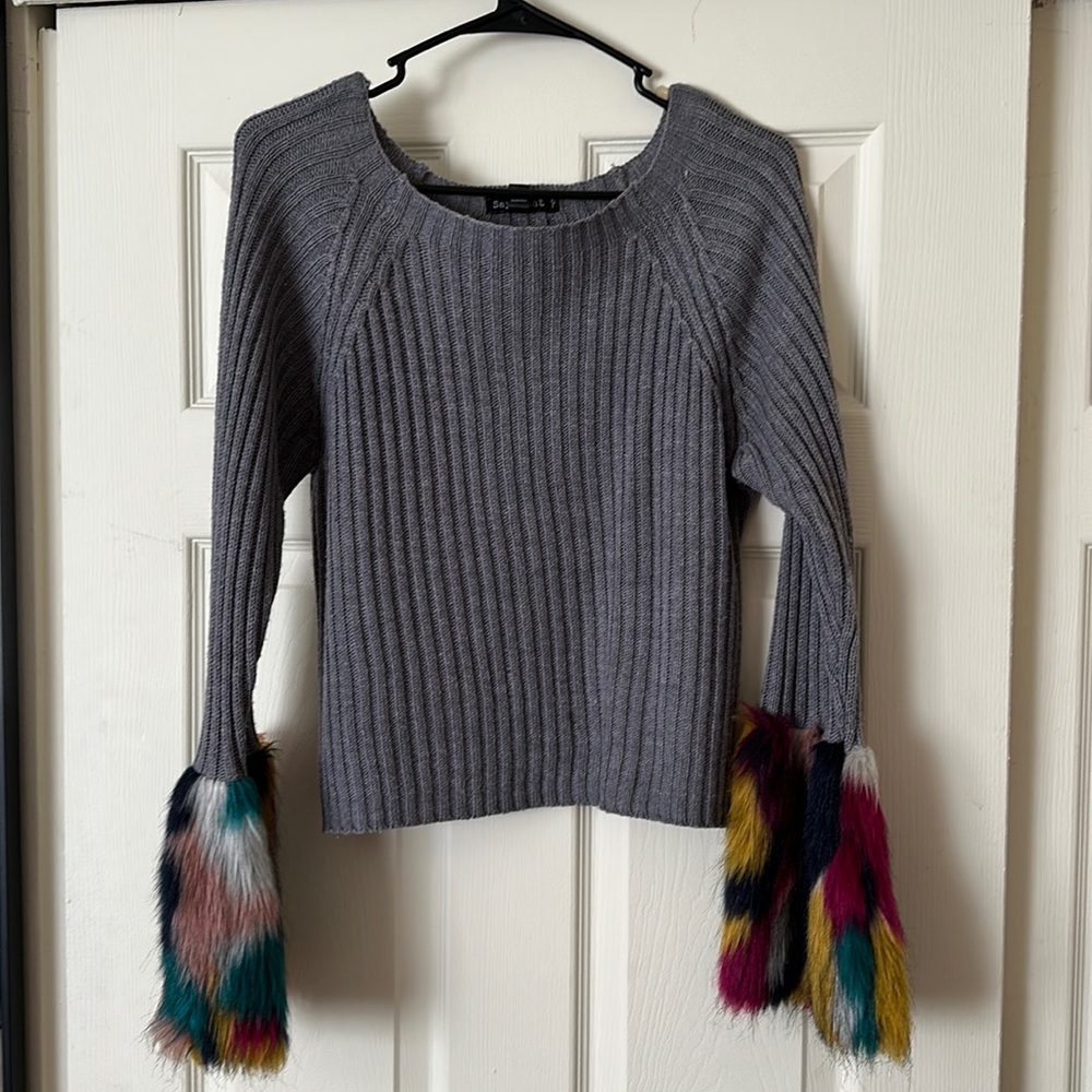 A grey sweater w/ fur at the end.